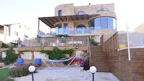 A stone house with a balcony, outdoor seating, and a garden. - Villa Herodion (Tekoa)
