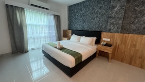 Quarto de hotel moderno com uma cama grande, uma mesa de cabeceira de madeira, um telefone e uma parede de destaque em mármore.