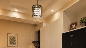 Una cocina moderna con armarios blancos, un refrigerador negro y un comedor con sillas amarillas.