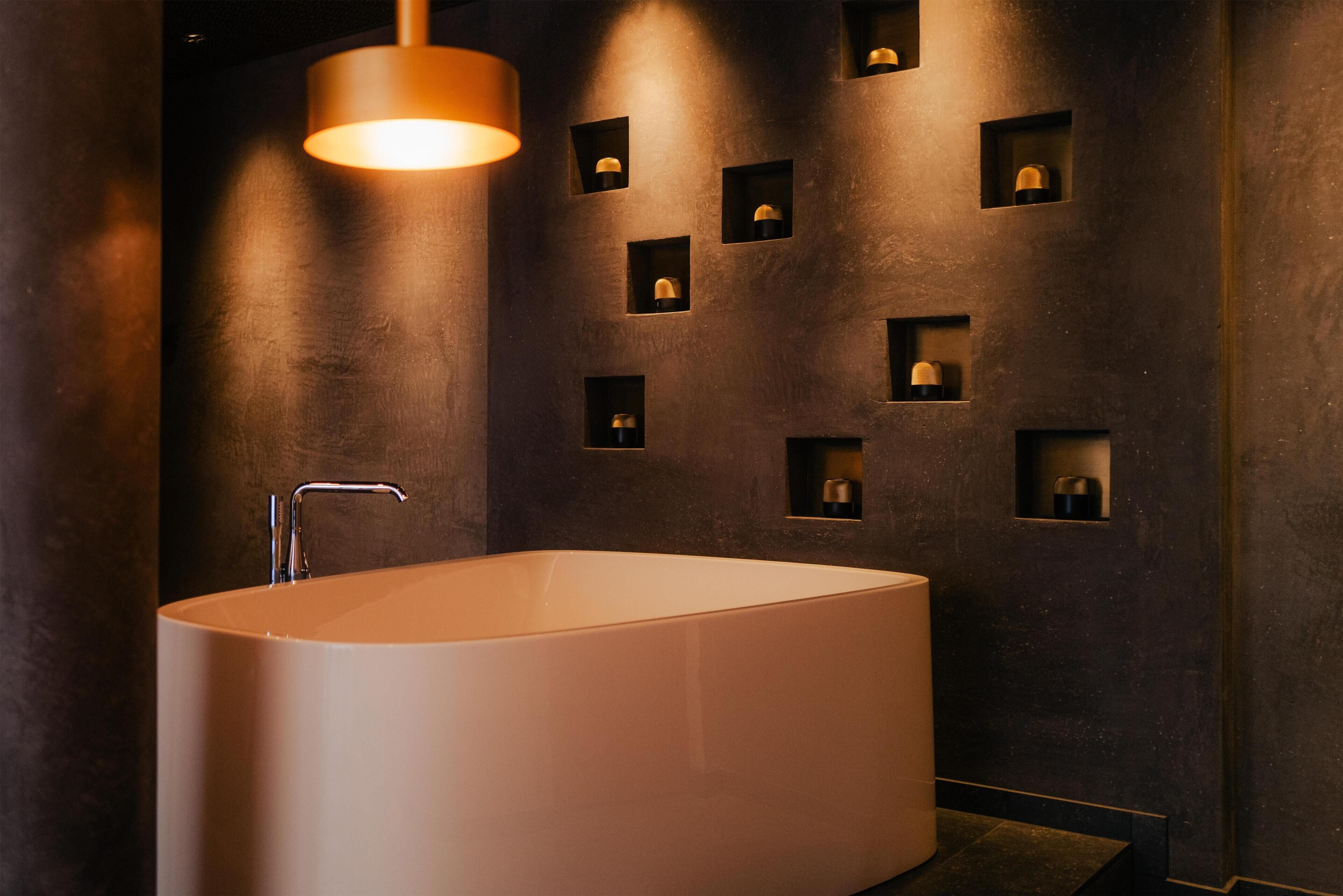 Une salle de bain moderne avec une baignoire sur pieds, un éclairage encastré et un design minimaliste.