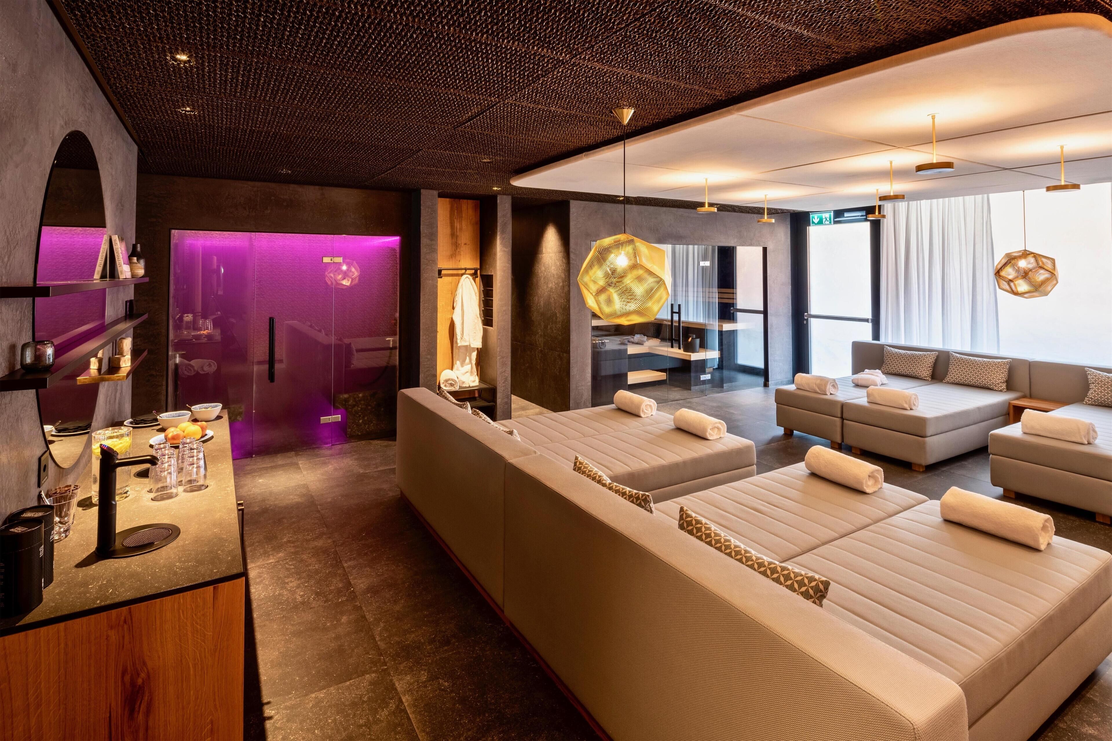 Un moderno spa con un amplio espacio de estar, una camilla de masaje y una recepción con servicios.