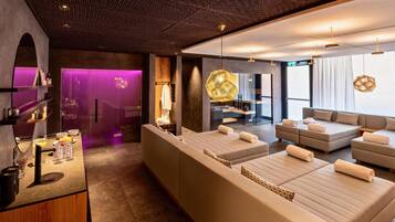 Un moderno spa con un amplio espacio de estar, una camilla de masaje y una recepción con servicios.