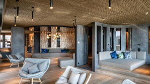 A modern interior with a curved seating area, wooden flooring, and a textured ceiling.
