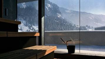 Un interior moderno con un banco de madera y vistas a montañas nevadas a través de amplios ventanales.