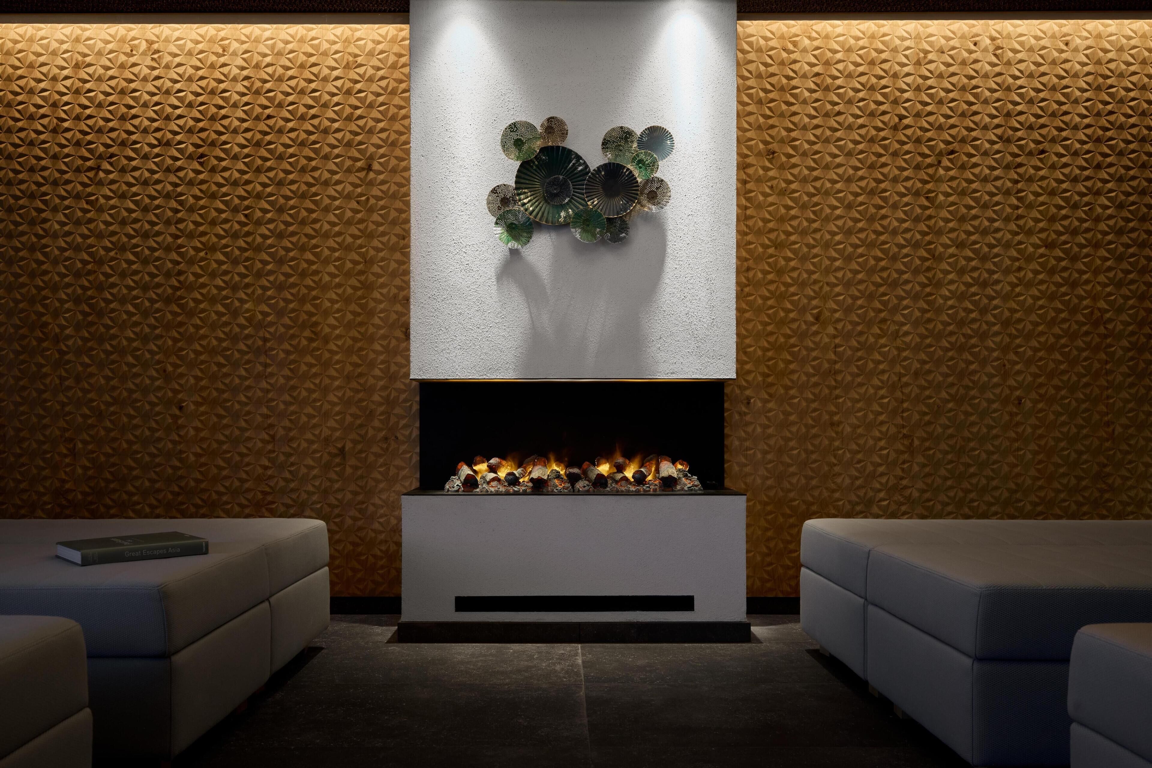 A modern interior with a fireplace, seating area, and textured wall.