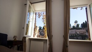A bedroom with a large window, a radiator, and a bed. - Fori Romani B&B (Rome)