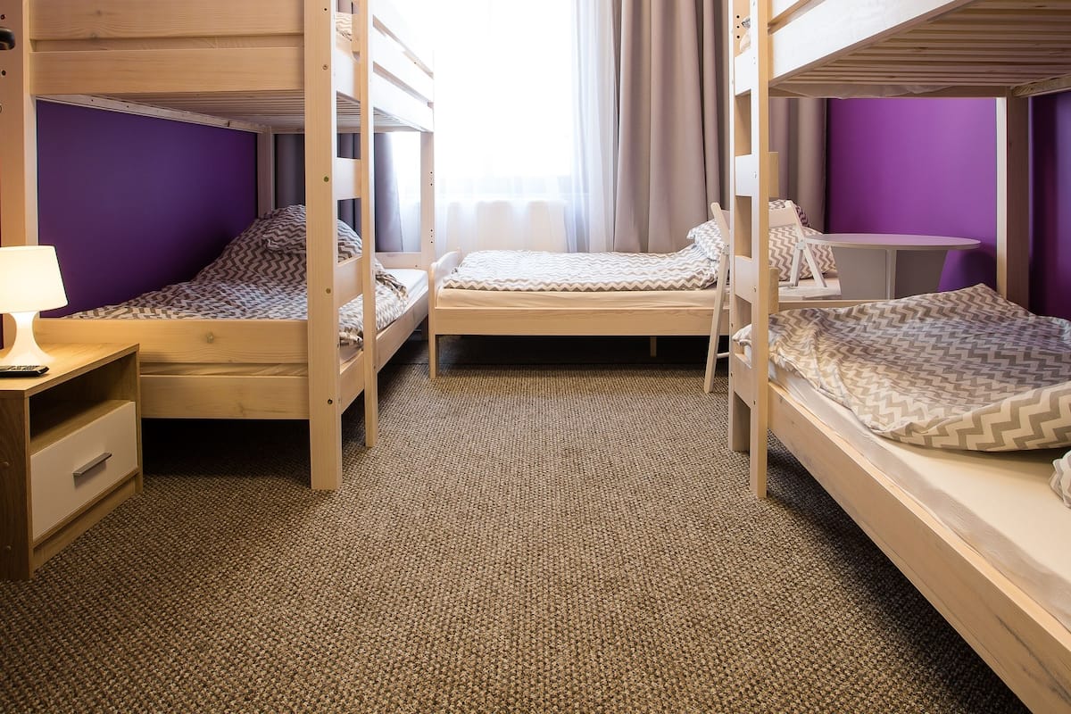 Ein Zimmer mit Etagenbetten, einem Schreibtisch und einem Stuhl.