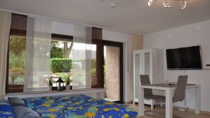 A bedroom with a bed, a desk, and a TV. - Ferienwohnung Schelsen (Moenchengladbach)