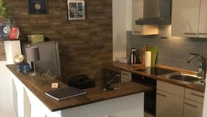 A modern kitchen with a central island, a built-in oven, and a stainless steel sink. - Ferienwohnung Schelsen (Moenchengladbach)