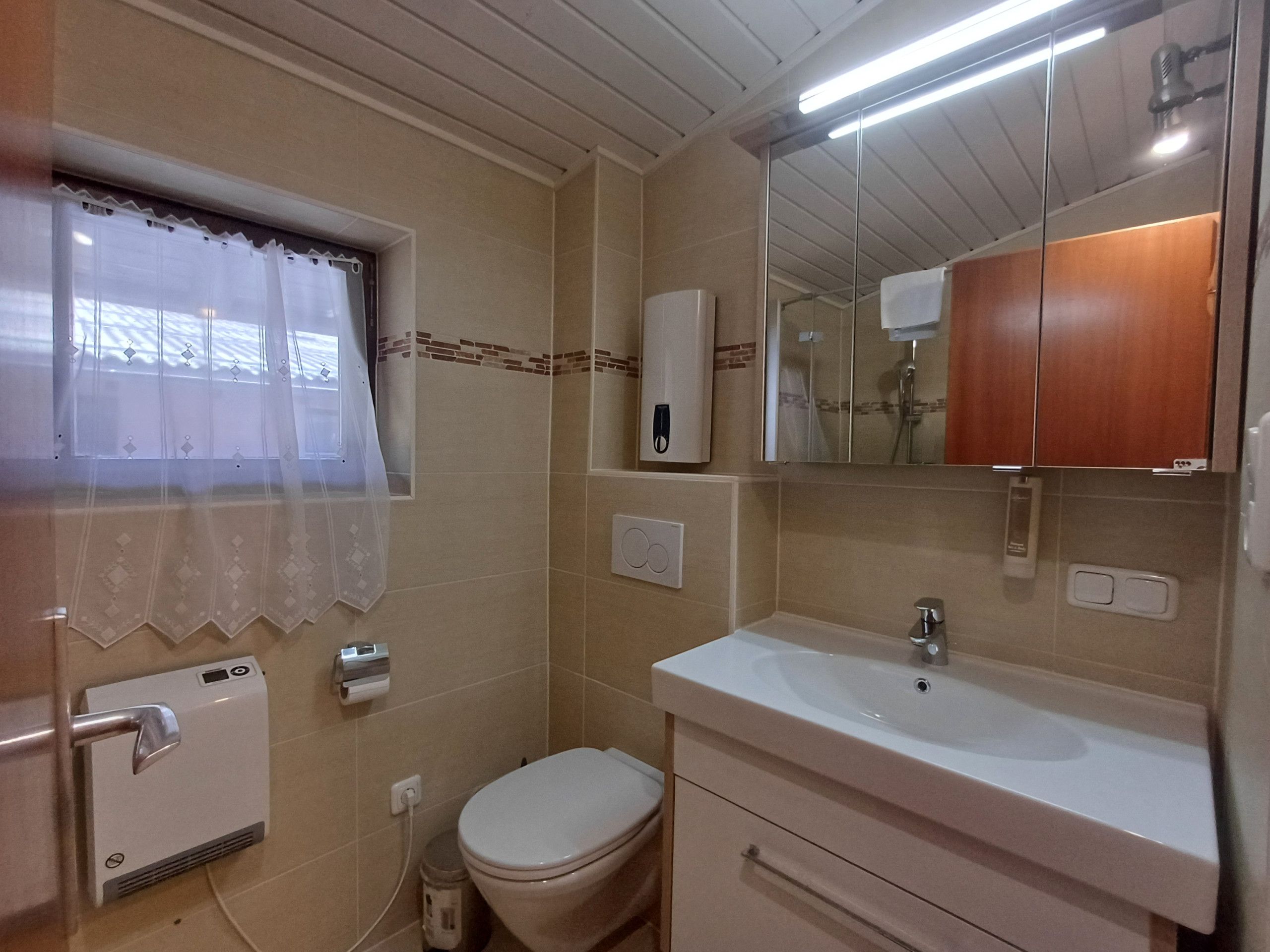 Une salle de bain avec des toilettes, un lavabo et un miroir.