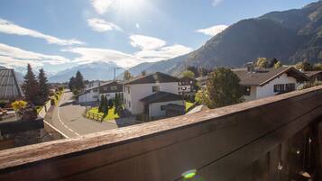 Ein Wohngebiet mit Häusern, einer Straße und Bergen im Hintergrund.
