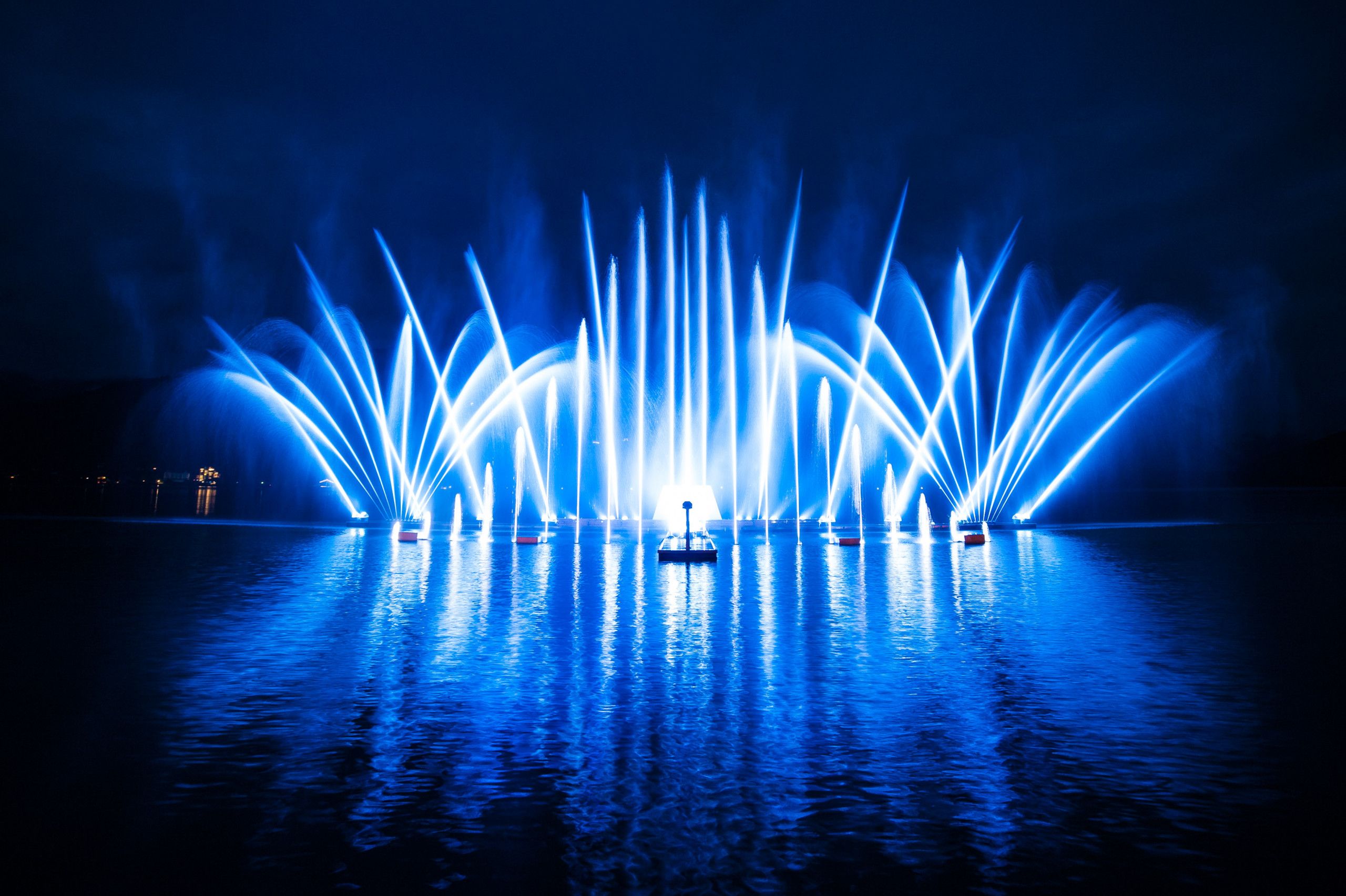 Een waterfonteinfunctie met meerdere waterstralen, verlicht met blauw licht.