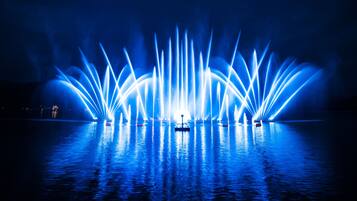 Een waterfonteinfunctie met meerdere waterstralen, verlicht met blauw licht.