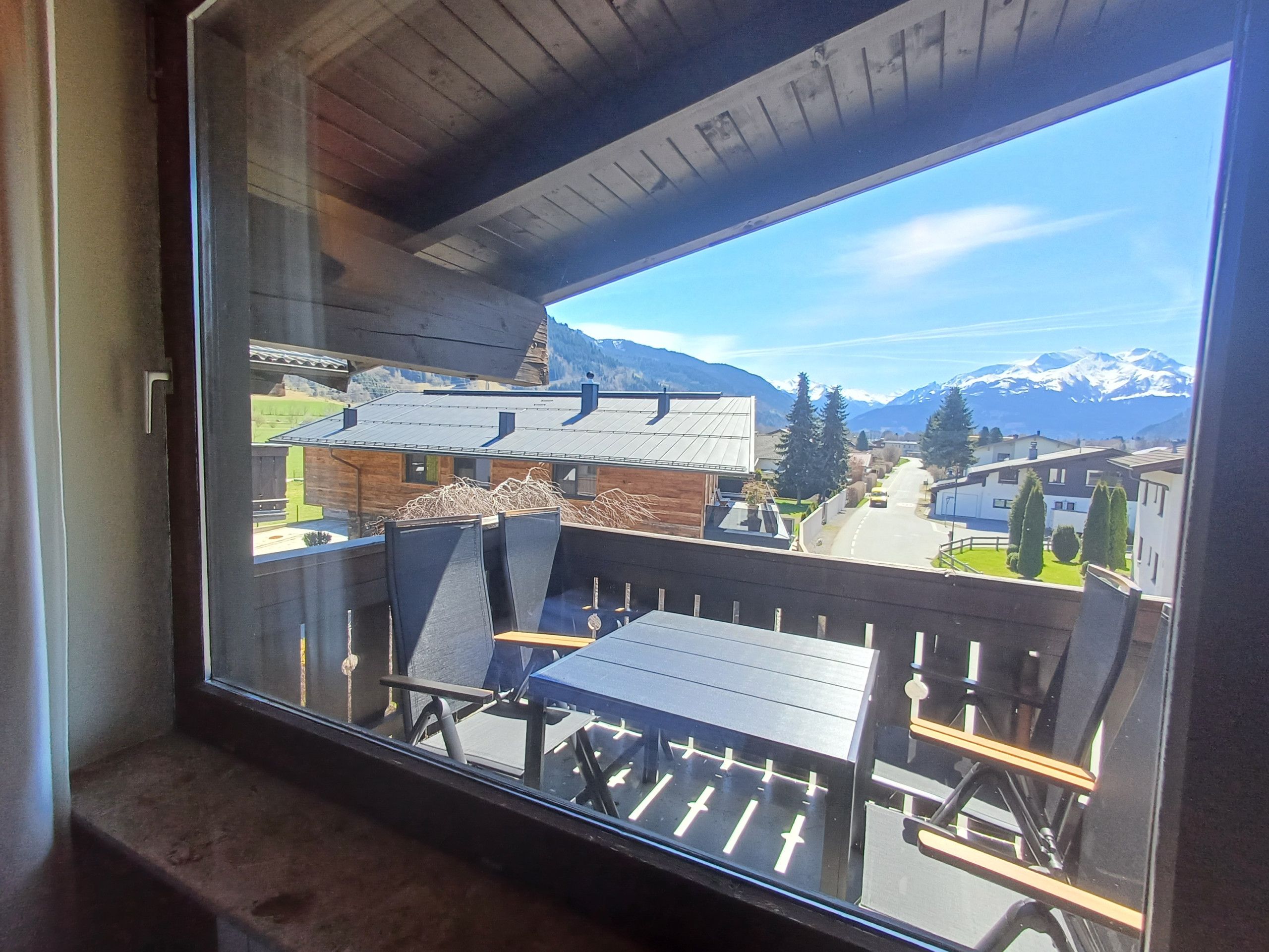 Ein Balkon mit Blick auf ein Gebirge und eine darunterliegende Stadt.