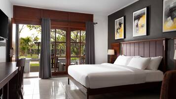 Habitación de hotel con cama, escritorio y vista al exterior a través de amplios ventanales.