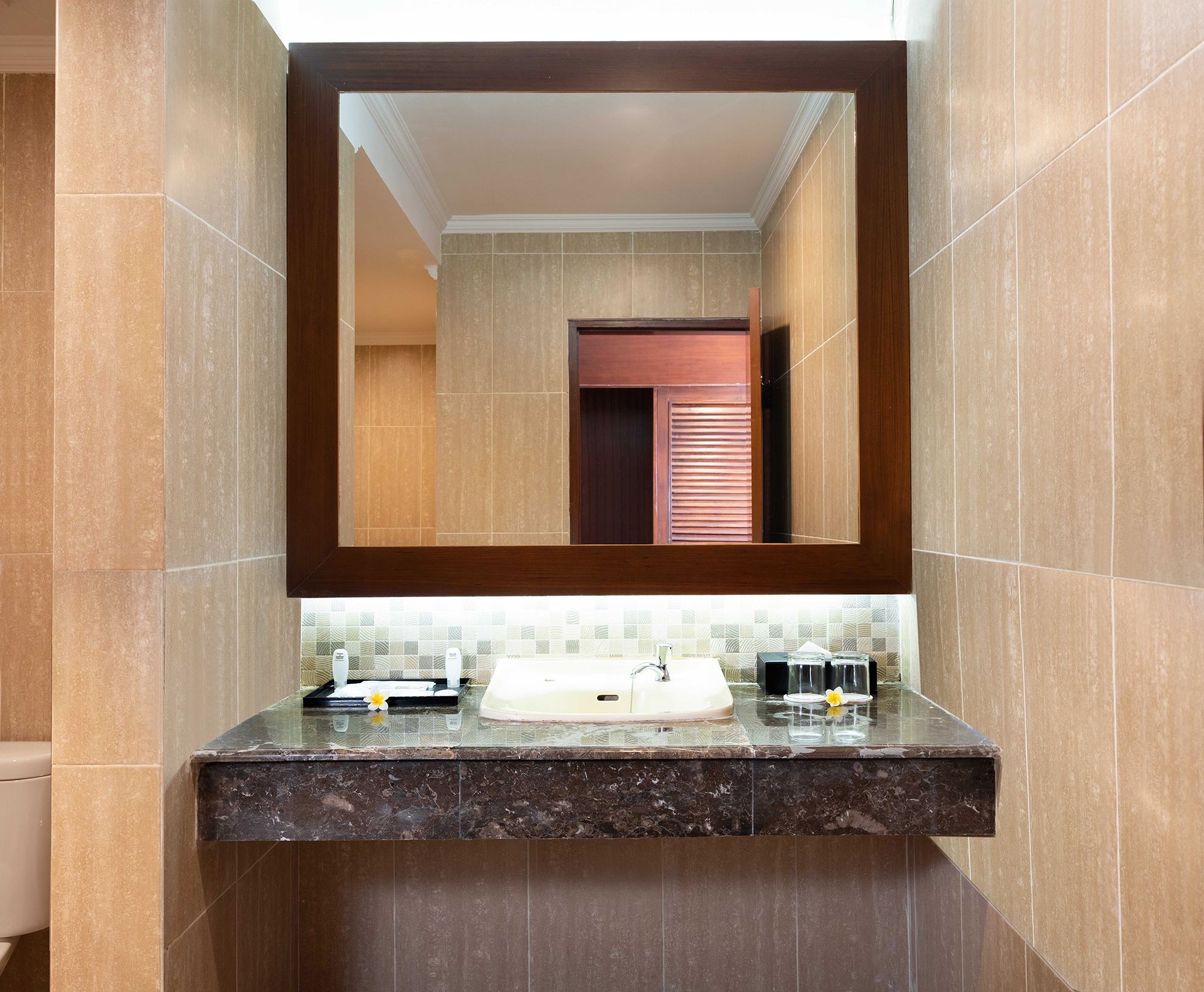 A bathroom with a marble countertop, a sink, and a mirror.