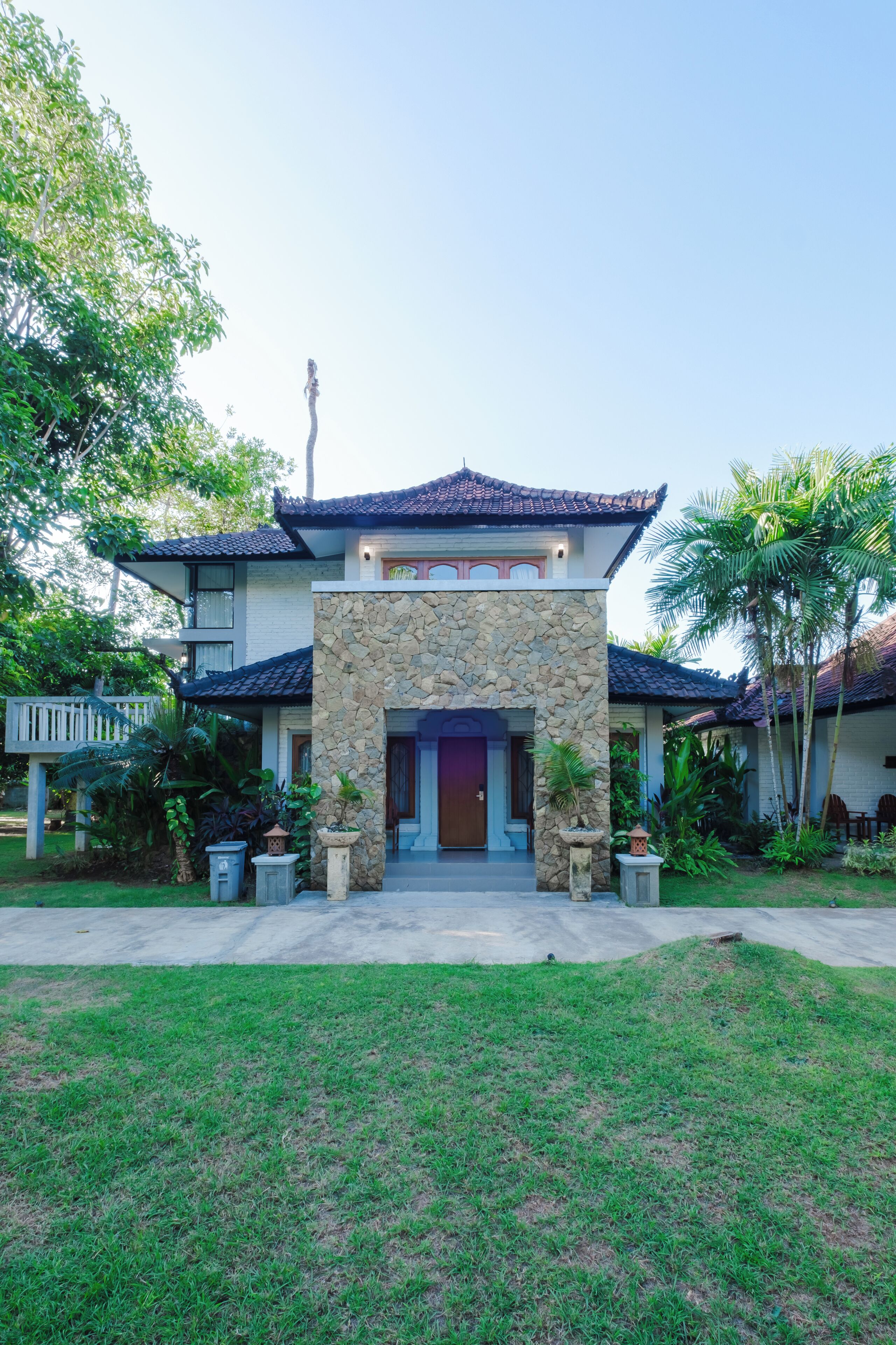 A traditional building with a stone facade, a tiled roof, and a well-maintained garden.