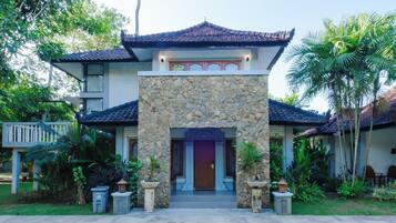 A traditional building with a stone facade, a tiled roof, and a well-maintained garden.