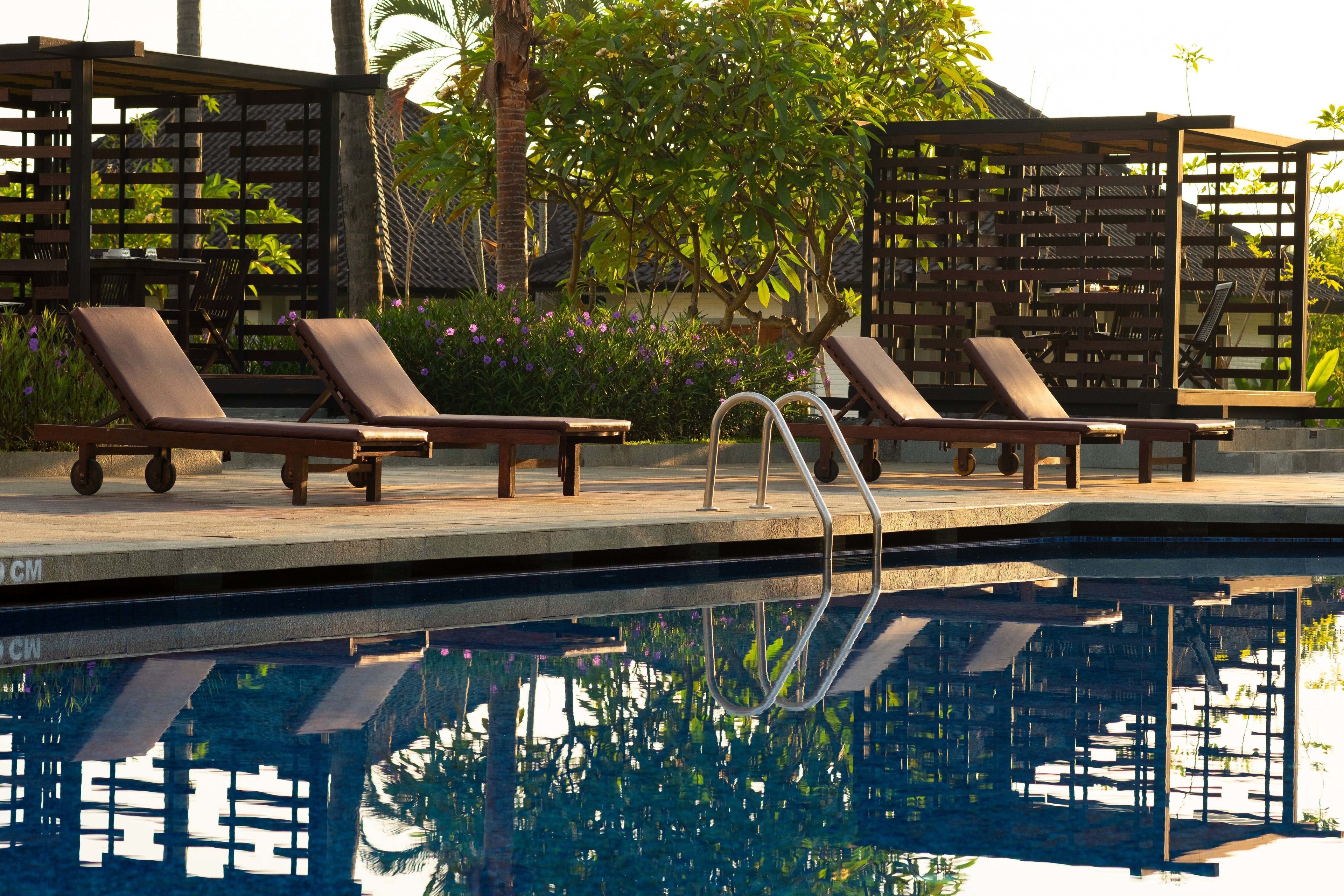 Un espace aménagé au bord de la piscine, avec des chaises longues et une piscine.