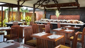 Un ristorante con tavoli e sedie in legno, un pilastro in pietra e un muro in mattoni.
