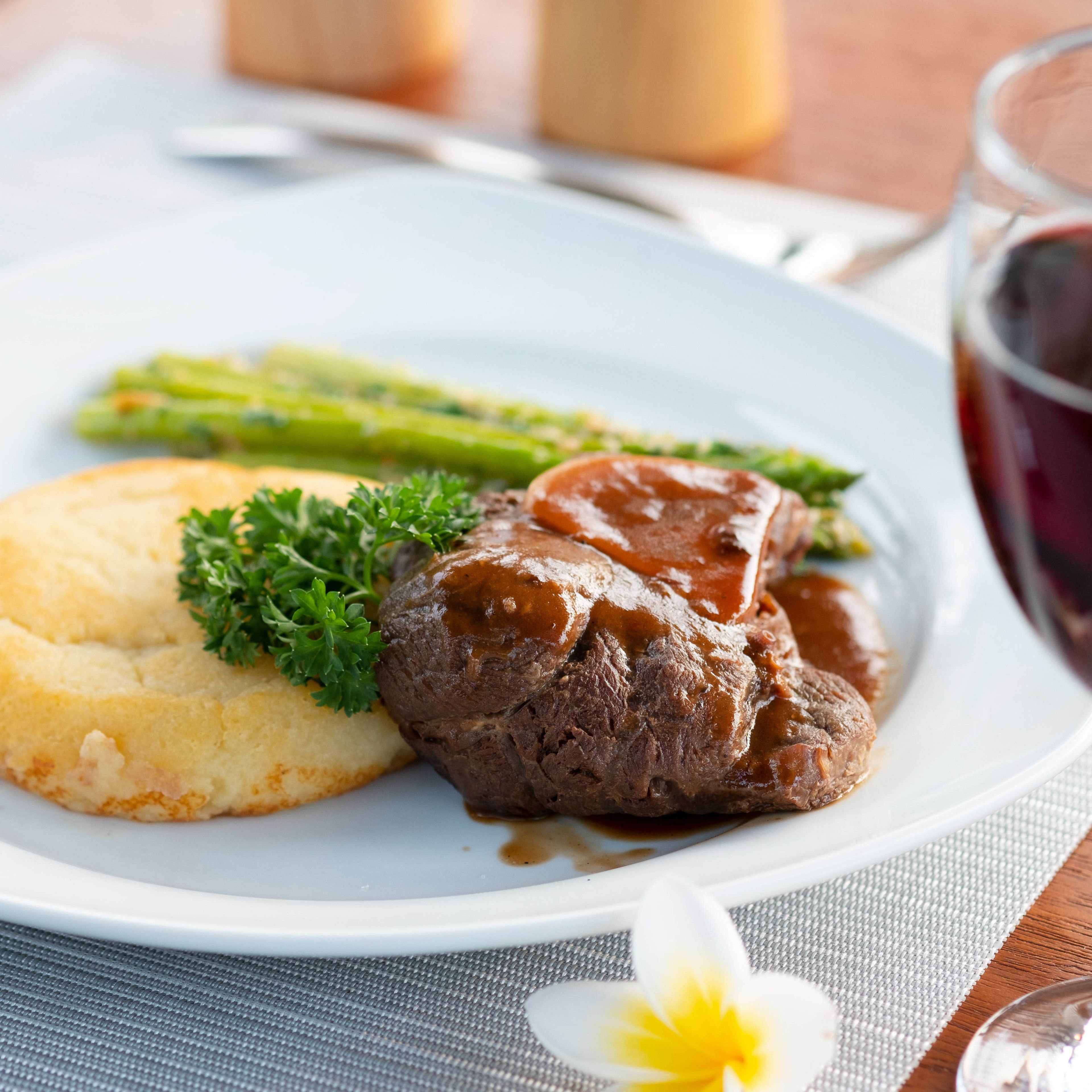 A plate with a beef steak, mashed potatoes, and asparagus.