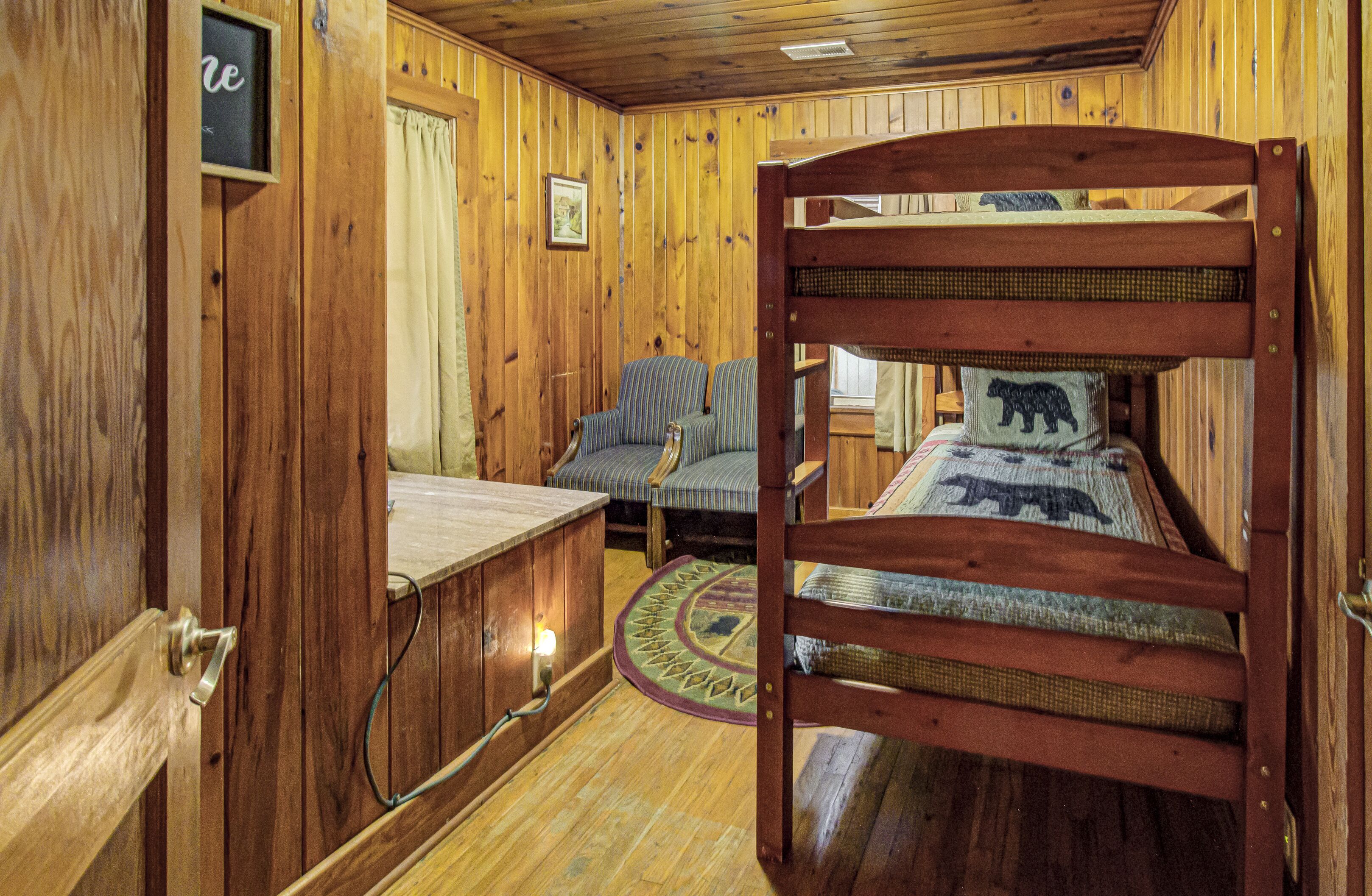 Ein Holzblockhaus-Interieur mit einem Etagenbett, einer Couch und einem kleinen Tisch.