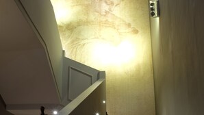 Escada com luminária no alto e corrimão à esquerda.