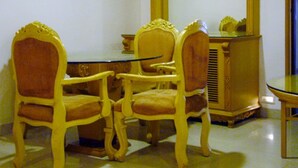 A room with two wooden chairs and a glass table. - Sana Heritage Inn Hyd (Hyderabad)
