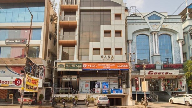 A multi-story building with various commercial establishments on the ground floor, including a fitness center, a beauty salon, and a hotel. - Sana Heritage Inn Hyd (Hyderabad)