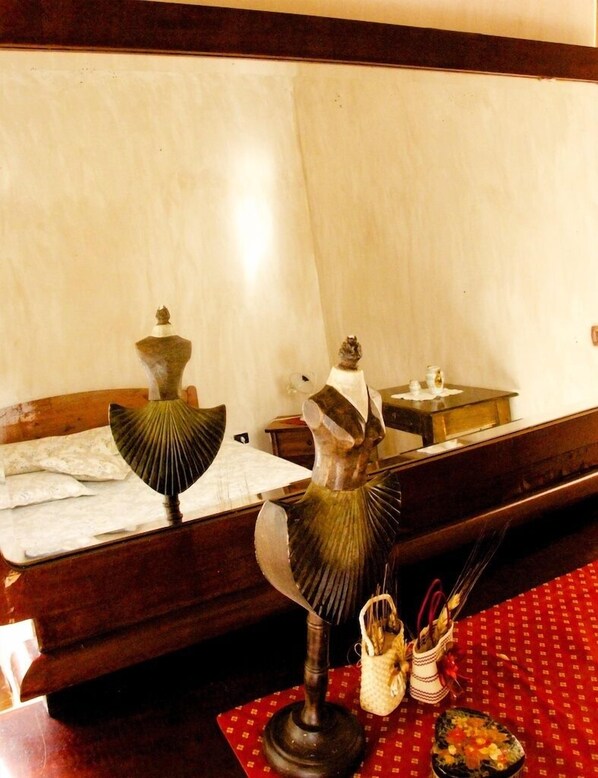 A room with a bed, a small table with a lamp, and a decorative item on the table. - La Tavernola Agriturismo - Tenuta Mandia (Sicignano degli Alburni)