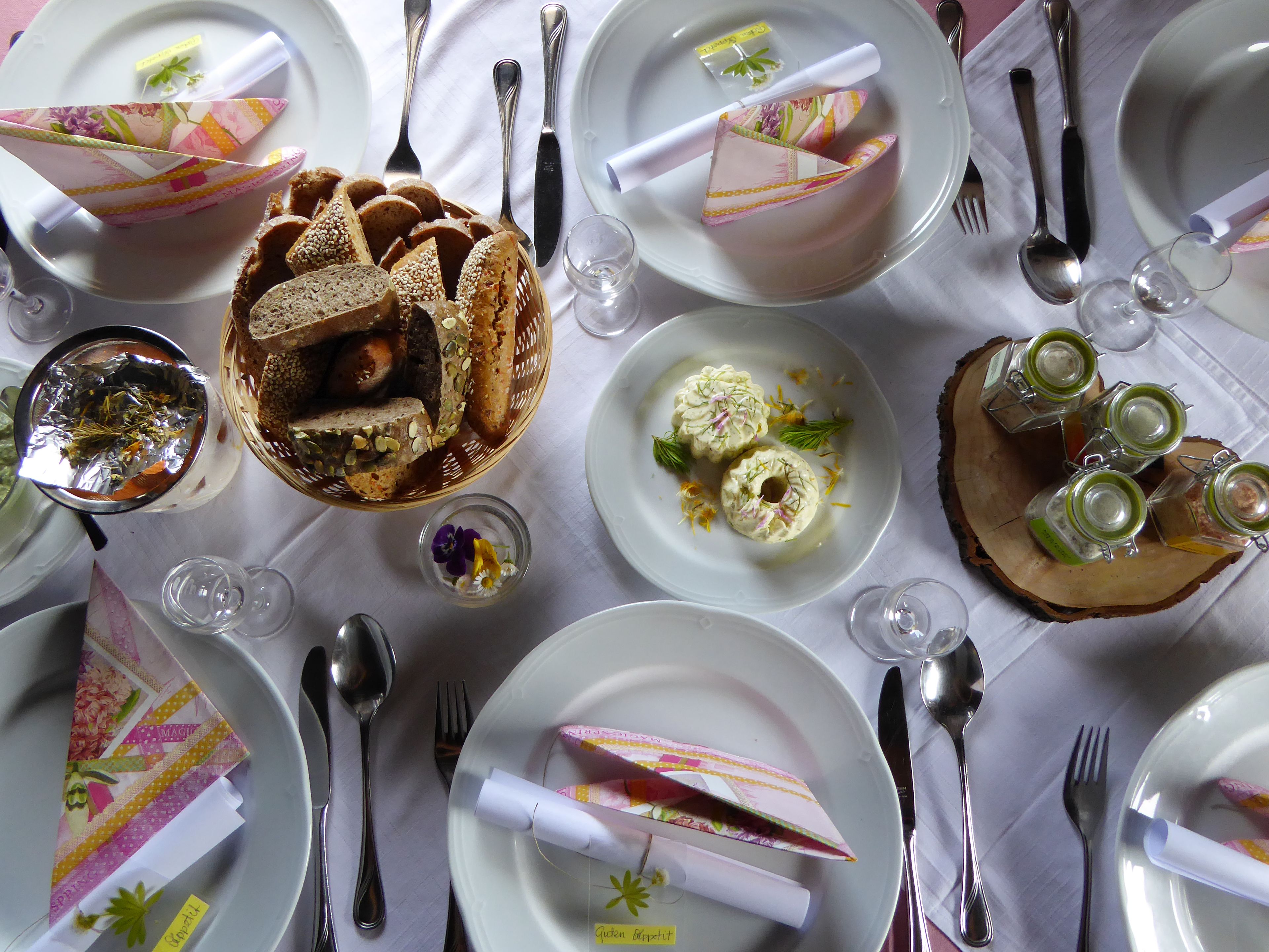 A table set for a meal with various dishes, utensils, and decorative elements.