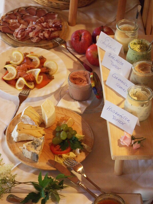 Una mesa con diversos alimentos y etiquetas, incluyendo queso, manzanas y un frasco de salsa.