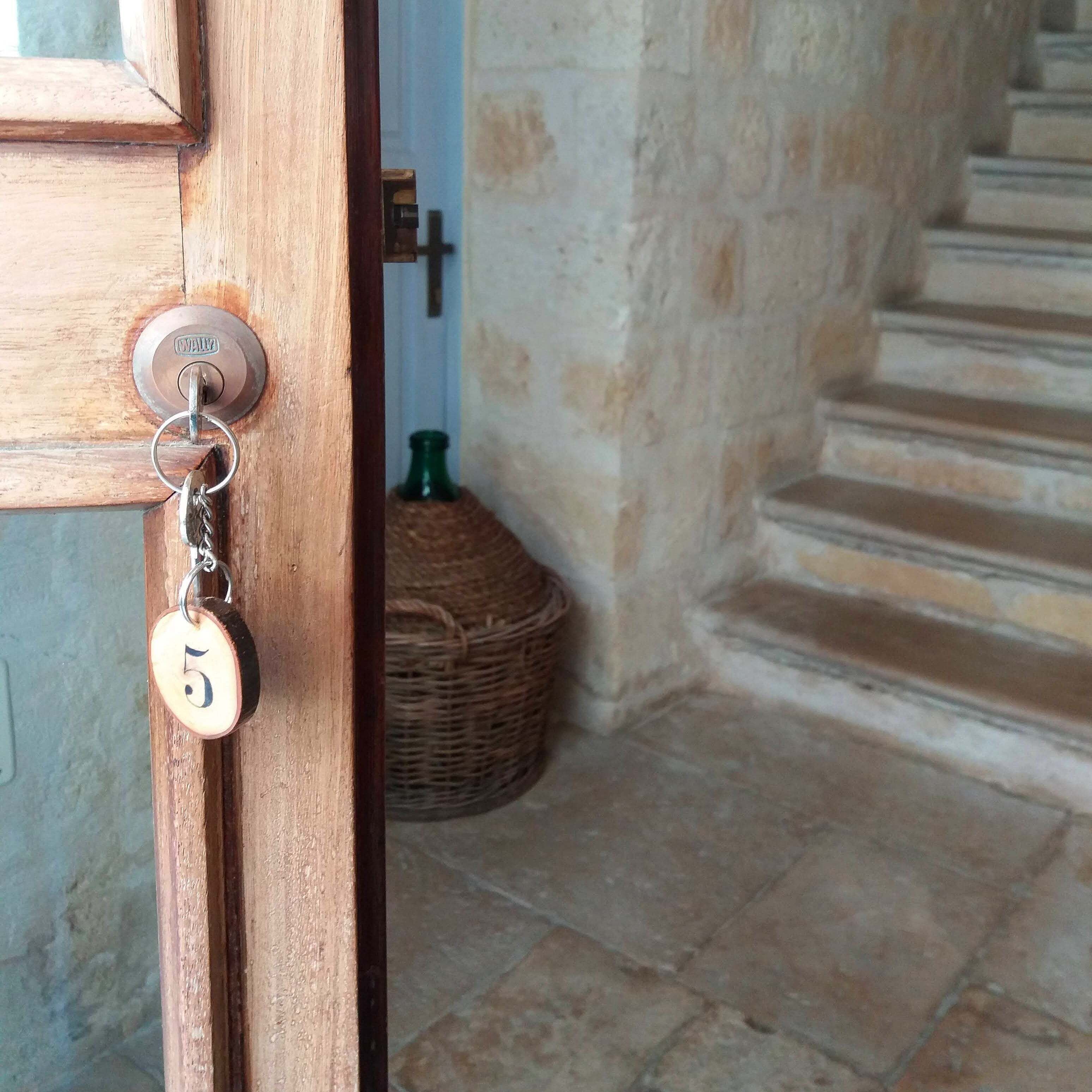 Una puerta de madera con una mirilla y un llavero con una etiqueta con el número 5.