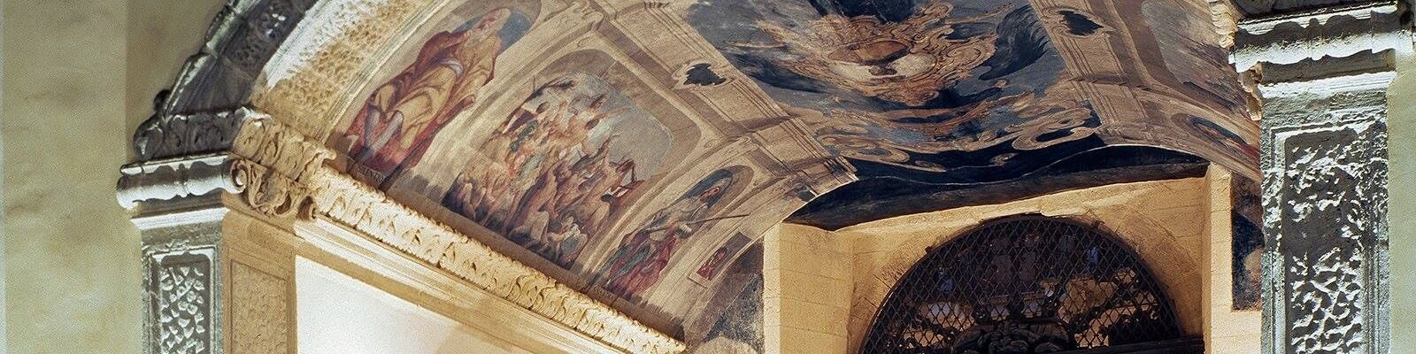 A detailed ceiling fresco with intricate designs and a central circular motif.