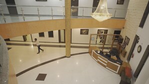 A hotel lobby with a reception desk, a large chandelier, and a high ceiling. - Dreams Resort Udaipur (Udaipur)