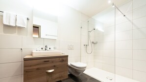 Une salle de bain moderne avec un meuble-lavabo en bois, des toilettes, une douche et une baignoire.