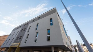 Un bâtiment moderne à la façade plate, doté de nombreuses fenêtres et d’un lampadaire.