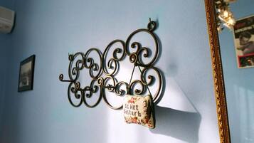 A wall-mounted decorative metal piece with a hanging cushion.