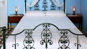 A bedroom with a bed, a chandelier, a mirror, and bedside lamps. - 5 Balconi (Catania)
