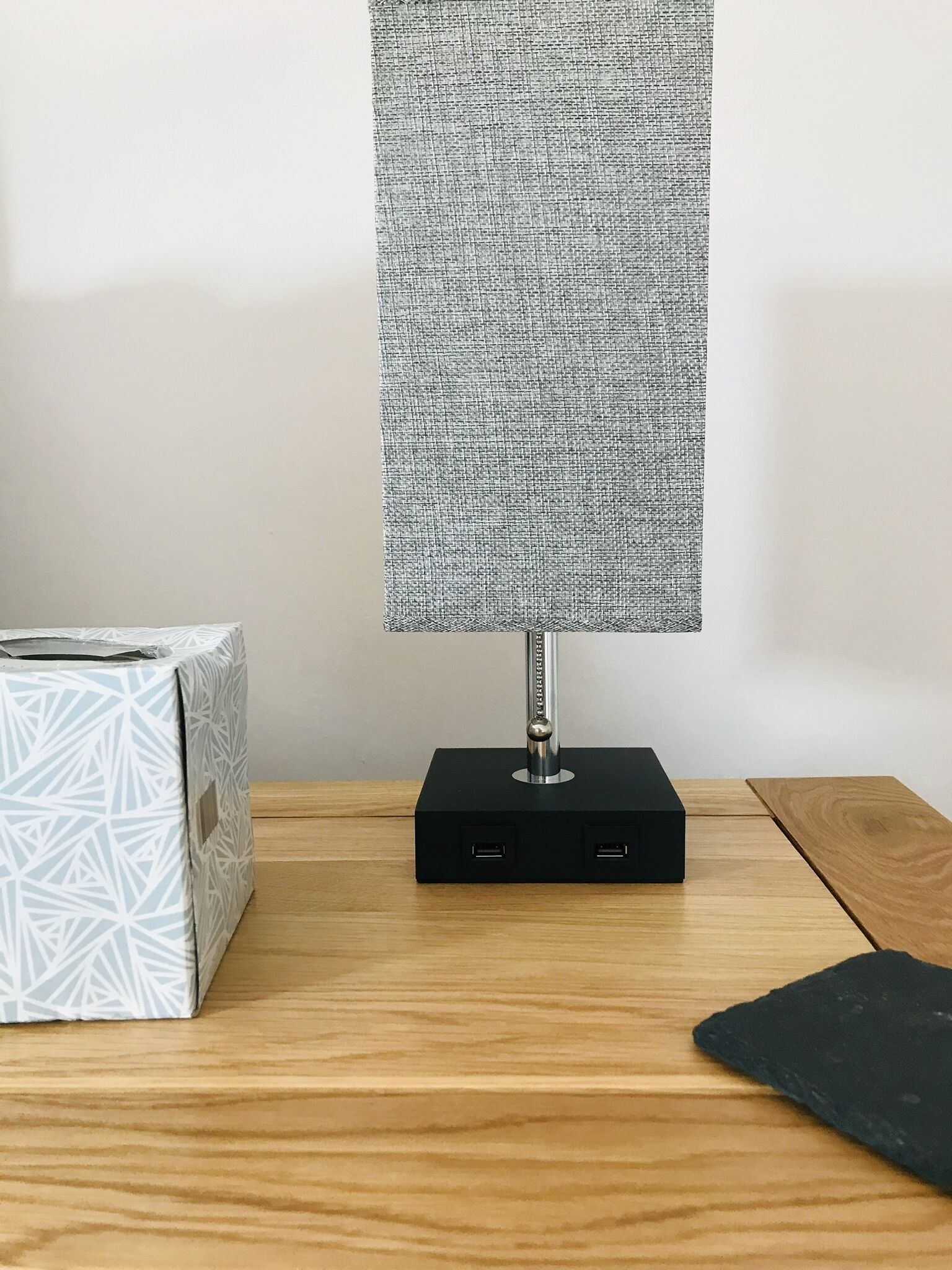 A table with a lamp, a box, and a black object.