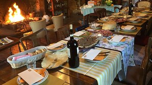 Un comedor con chimenea, mesas y sillas de madera.