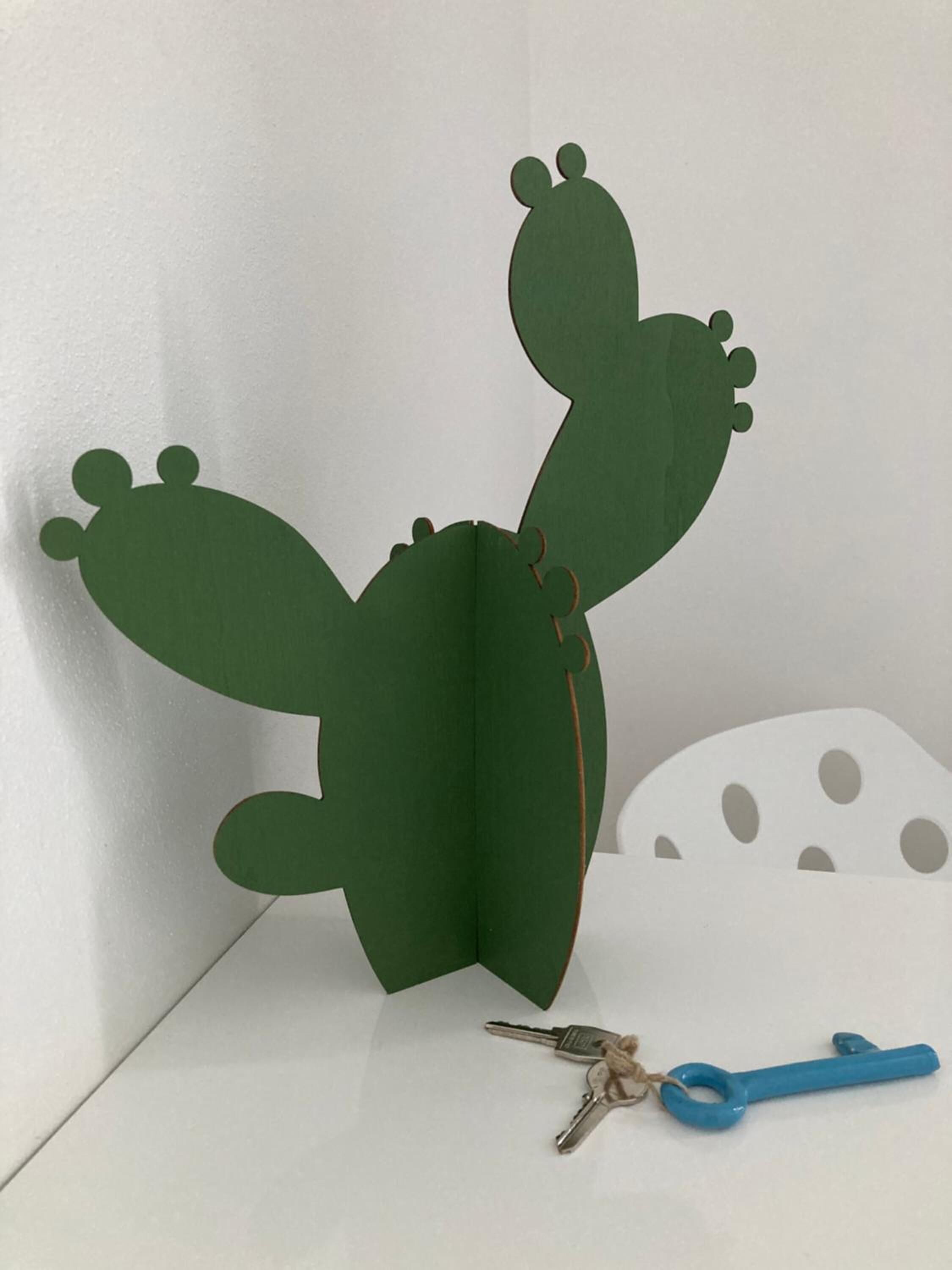 A cactus-shaped paper decoration with a pair of keys and a blue-handled knife beside it.