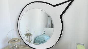 A round mirror with a black frame on a wall.