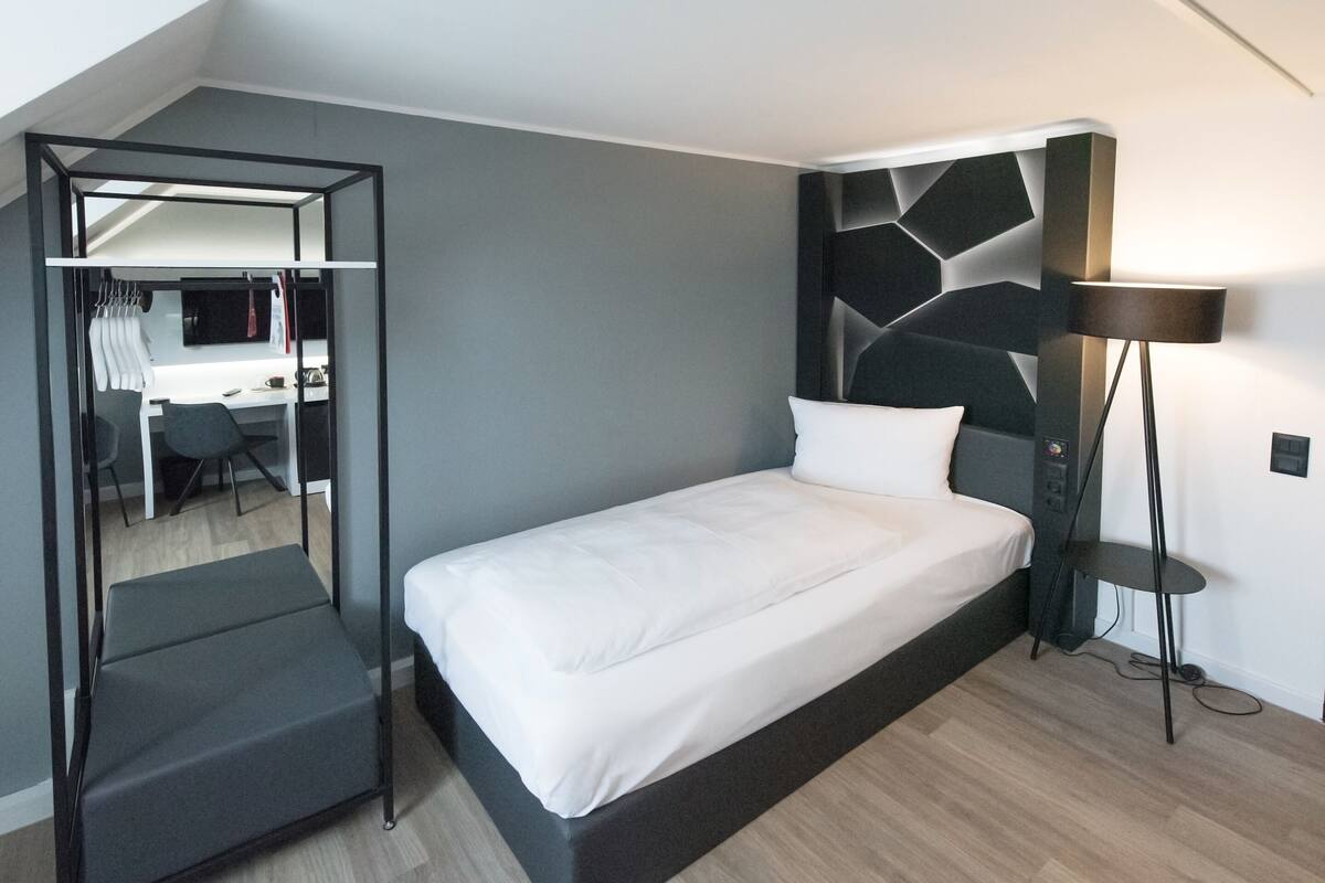 A modern bedroom with a bed, a desk, and a chair.