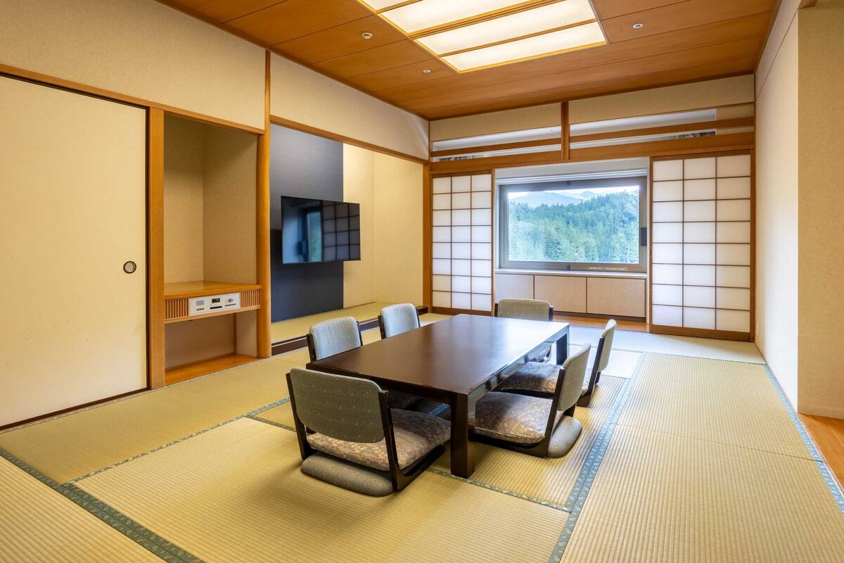 Une pièce de style japonais traditionnel, avec un sol recouvert de tatamis, une table basse et des paravents en papier de riz (shoji).