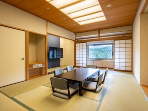 Una habitación tradicional japonesa con suelo de tatami, una mesa baja y paneles de shoji.