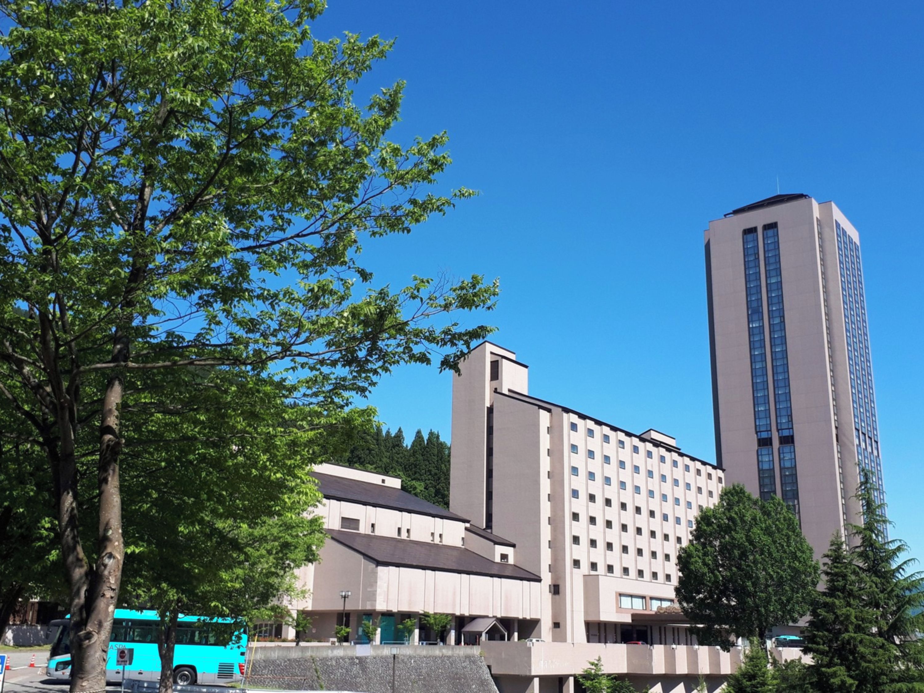 A modern building with a flat roof and a tall, rectangular tower.