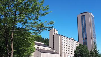 A modern building with a flat roof and a tall, rectangular tower.