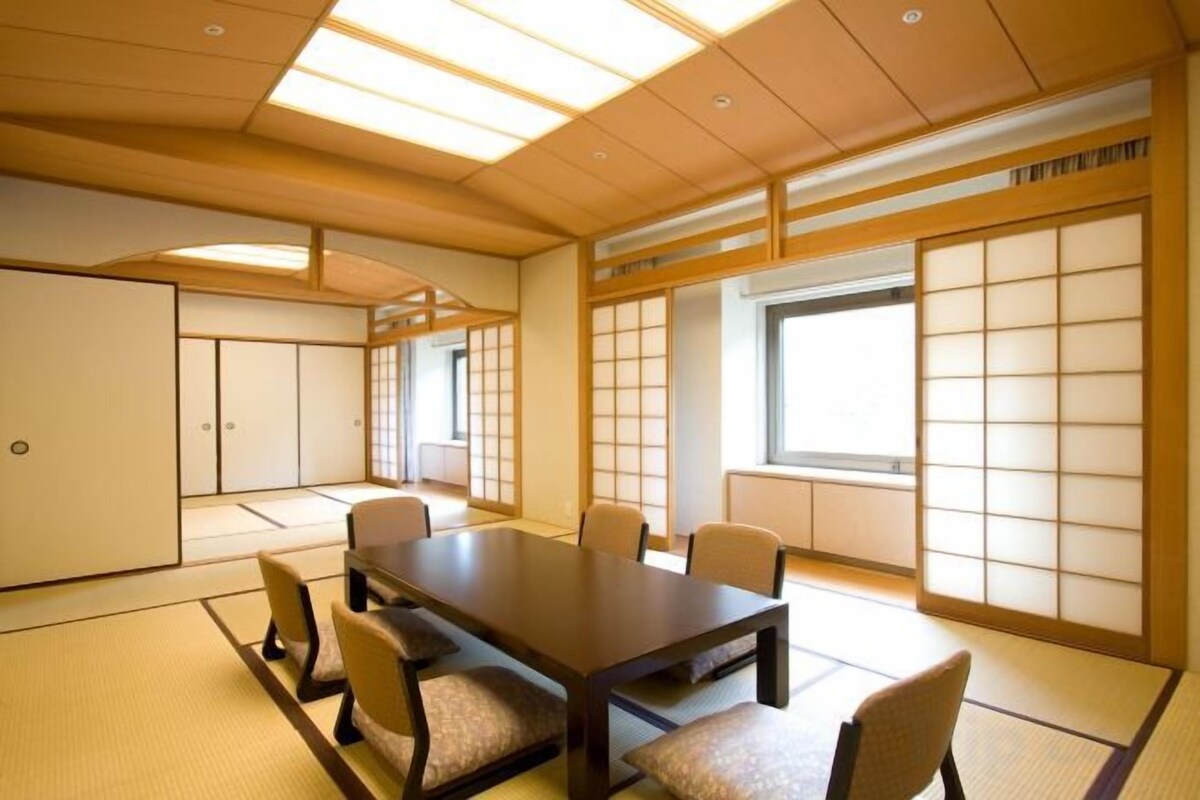 A traditional Japanese-style room with tatami flooring, a low table, and shoji screens.