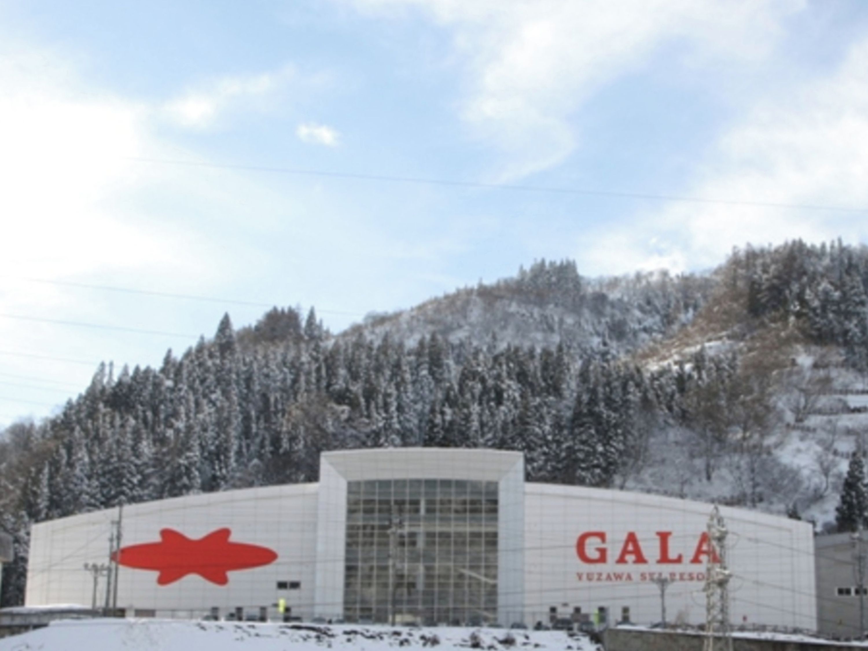 A building with a large red logo and the name 'GALA' on the facade.